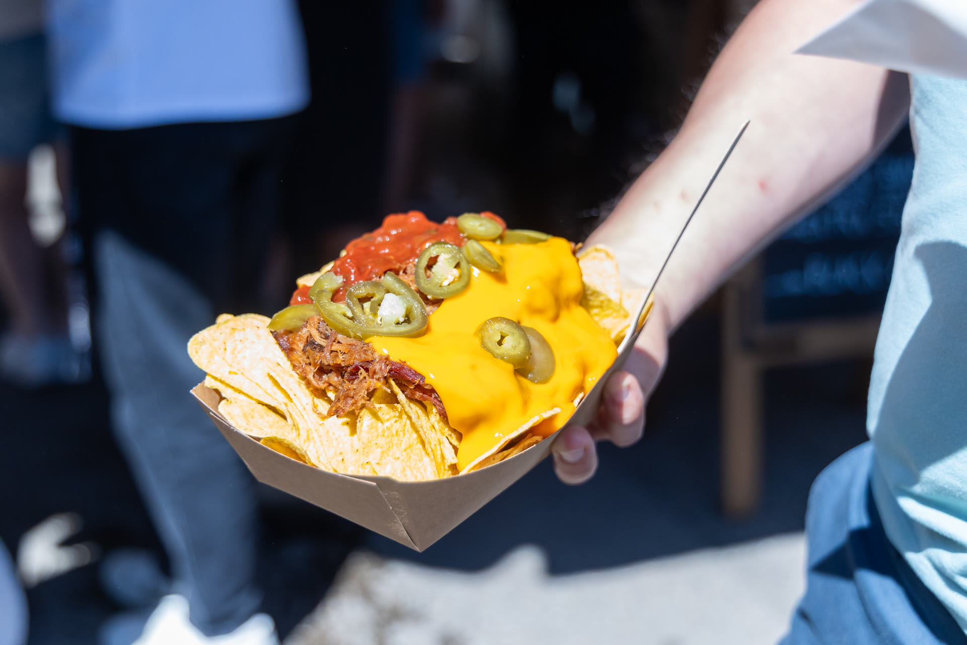 Nachos met pulled meat, kaassaus en jalapeño worden buiten geserveerd