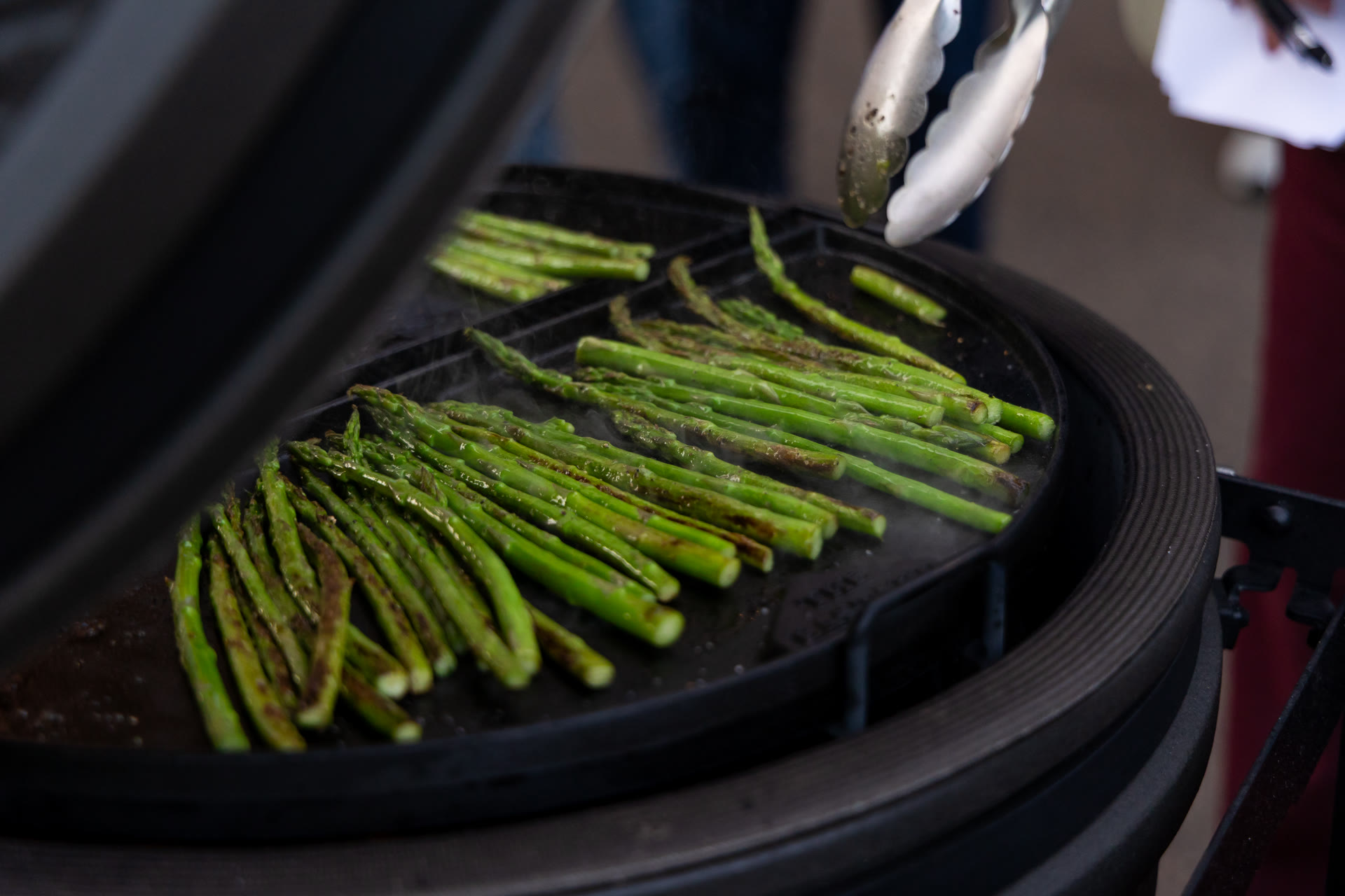 Groene asperges garen op een hete plaat in de kamado